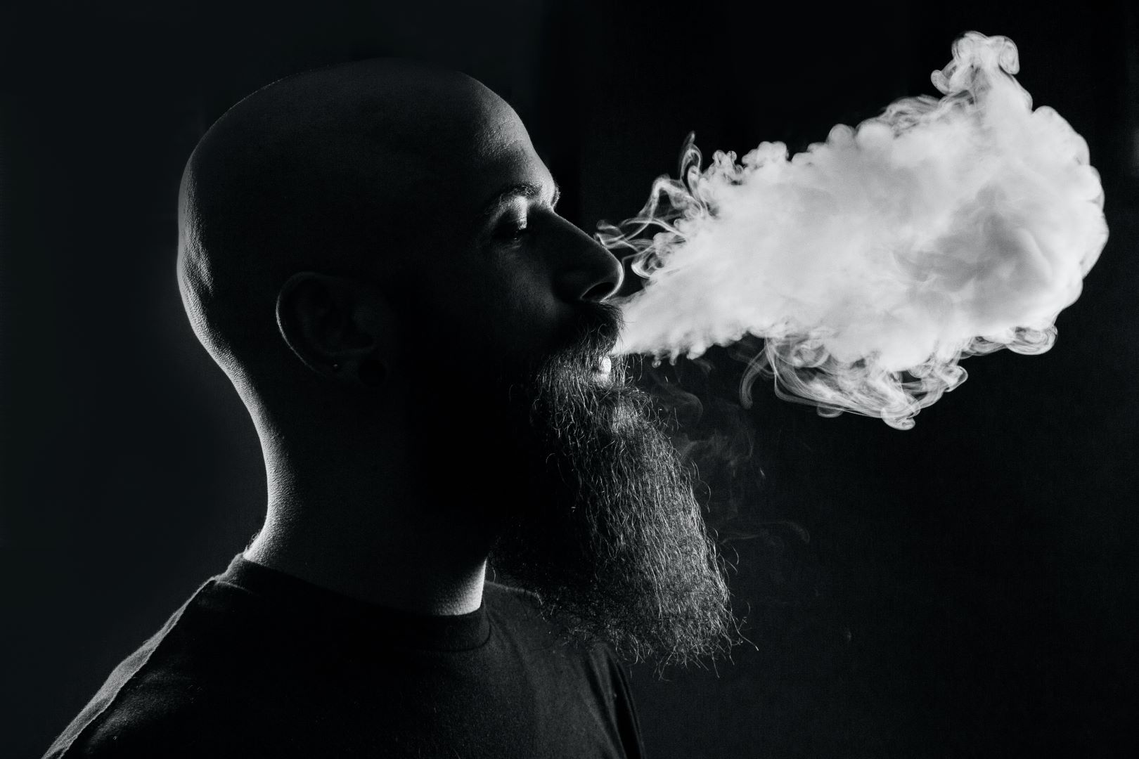 Bearded man smoking a vape pen with 3Chi